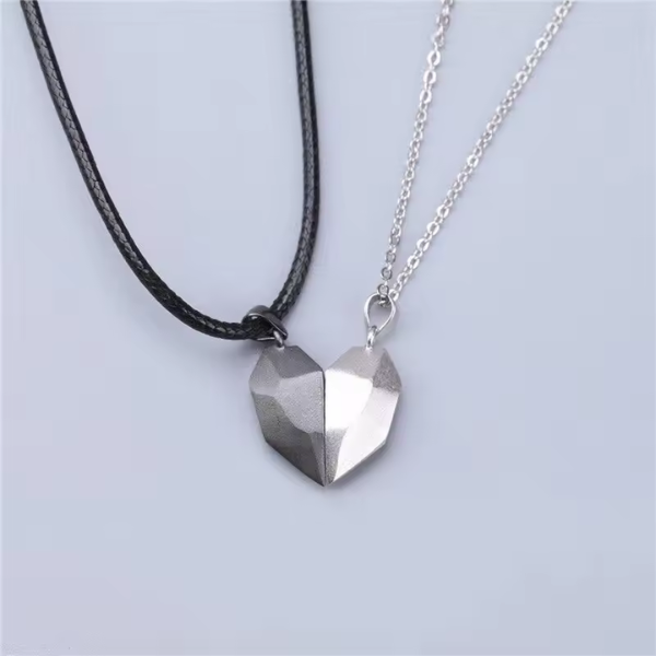 Collier aimanté cœur bicolore en noir et argent sur fond blanc