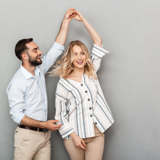 Un couple riant et dansant ensemble, illustrant un moment romantique parfait pour offrir un bijou.